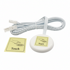 A white oval electronic sensor or control module with a coiled white cable and two connector ends, shown alongside a small yellow instruction card labeled 'Touch'.